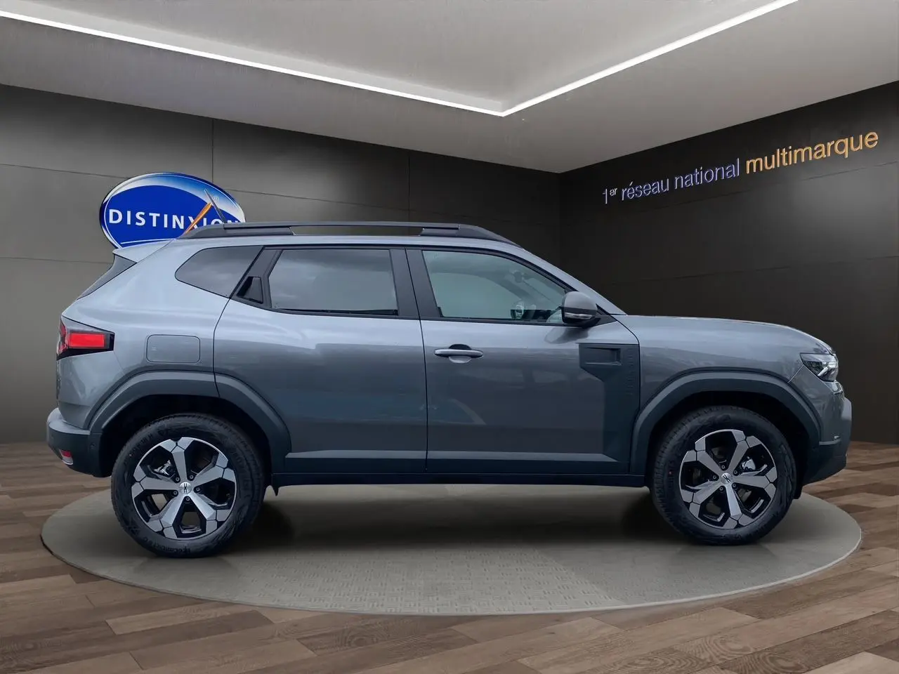 Profil droit du Dacia Duster 2025 gris schiste hybride 140 Journey 4x2 avec jantes alliage et toit noir.