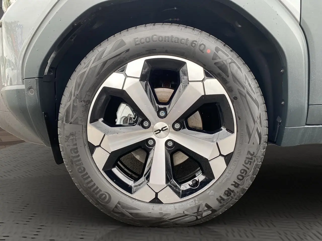 Gros plan sur la roue avant droite du Dacia Duster gris schiste, mettant en valeur la jante alliage au design moderne.