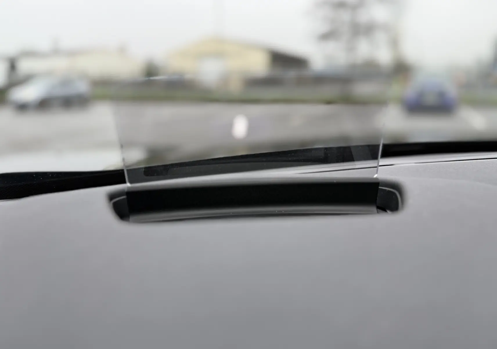 Affichage tête haute transparent du tableau de bord d'une DS3 2024 Diesel noir Perla Nera en extérieur flou.