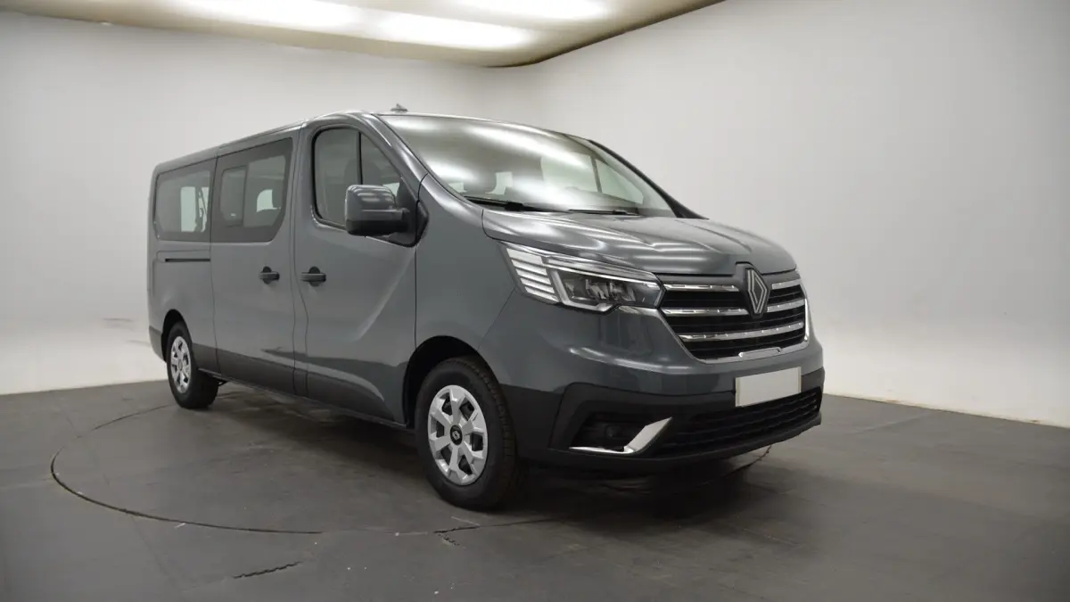 Vue 3/4 avant gauche d’un Renault Trafic Fourgon gris clair avec calandre chromée et feux LED dans un studio.