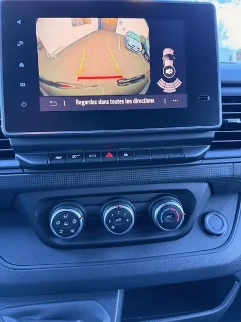 Vue intérieure du tableau de bord du Renault Trafic Fourgon gris clair 2025, écran tactile affichant la caméra de recul.