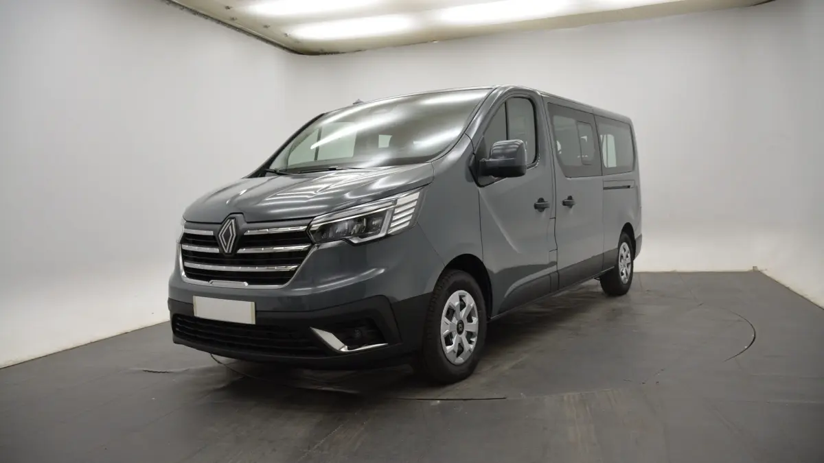 Renault Trafic Fourgon gris clair vu en 3/4 avant droit dans un studio avec calandre chromée et phares LED.