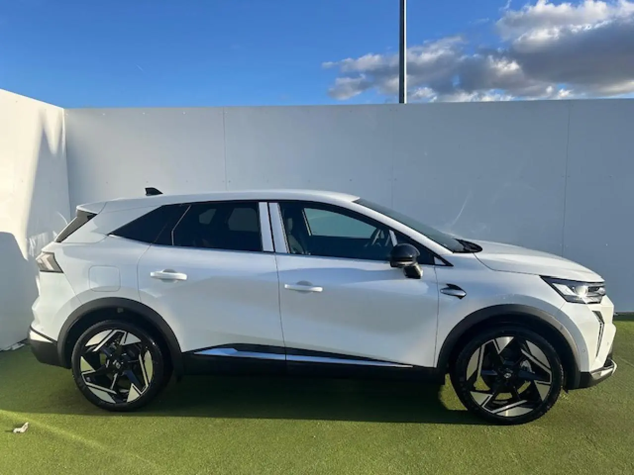Vue de profil côté gauche du Renault SYMBIOZ blanc nacré avec jantes alliage noires et détails noirs contrastants.