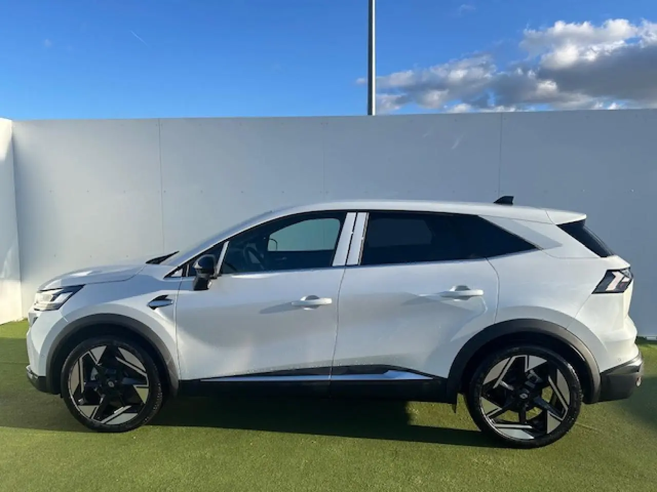 Profil côté gauche du Renault Symbioz blanc nacré avec jantes alliage noires et toit noir contrasté.