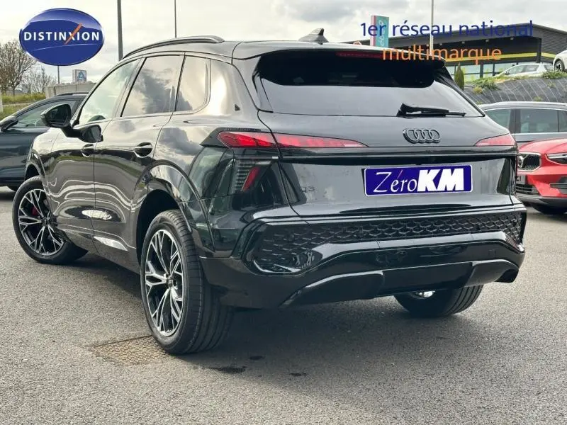 Audi Q3 2.0 TDI noir métallisé en 3/4 arrière droit, avec jantes alu et feux arrière LED allumés.