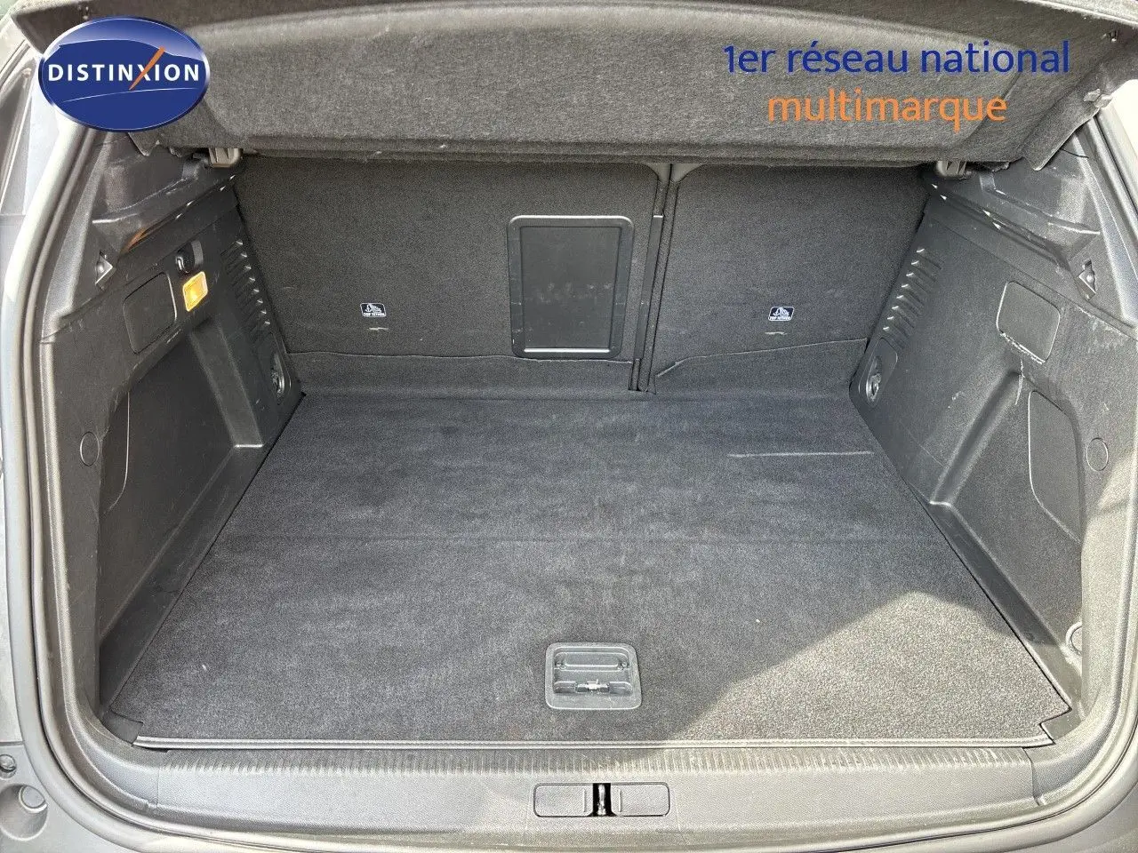Coffre ouvert en vue arrière d’un Peugeot 3008 gris platinium, montrant un espace de chargement propre et spacieux.