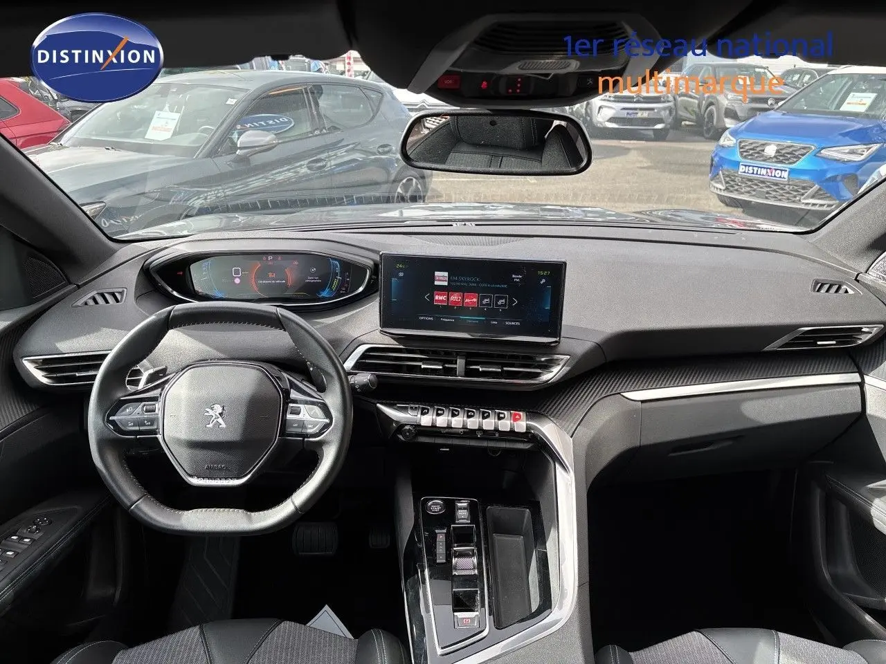 Vue intérieure avant du Peugeot 3008 Hybrid 180ch Allure 2024, tableau de bord moderne avec écran tactile et volant multifonction noir.
