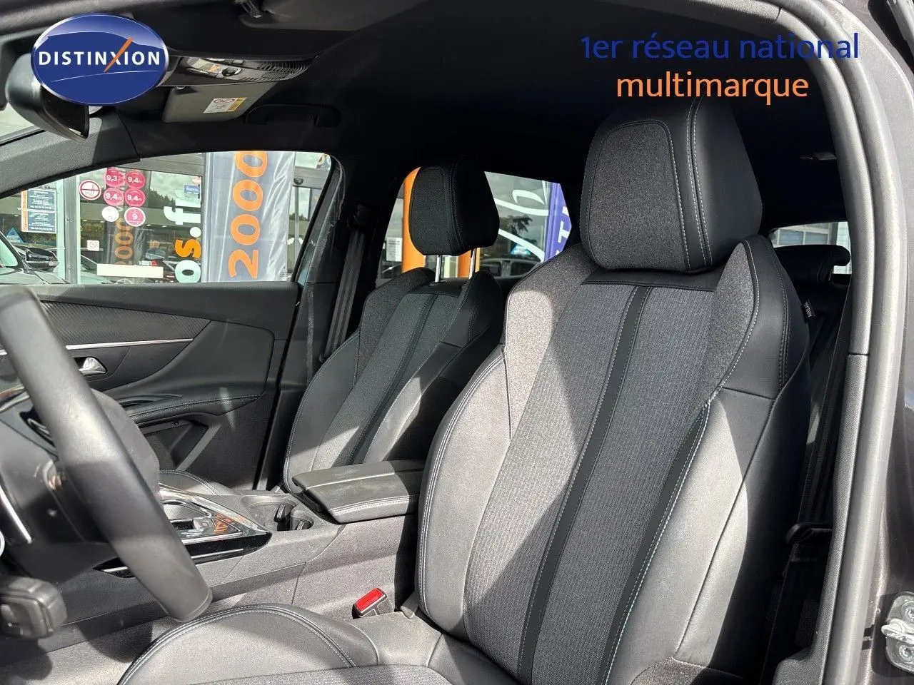 Vue intérieure côté conducteur du Peugeot 3008 Hybrid 180ch Allure 2024, sièges tissu et cuir noir avec surpiqûres grises.