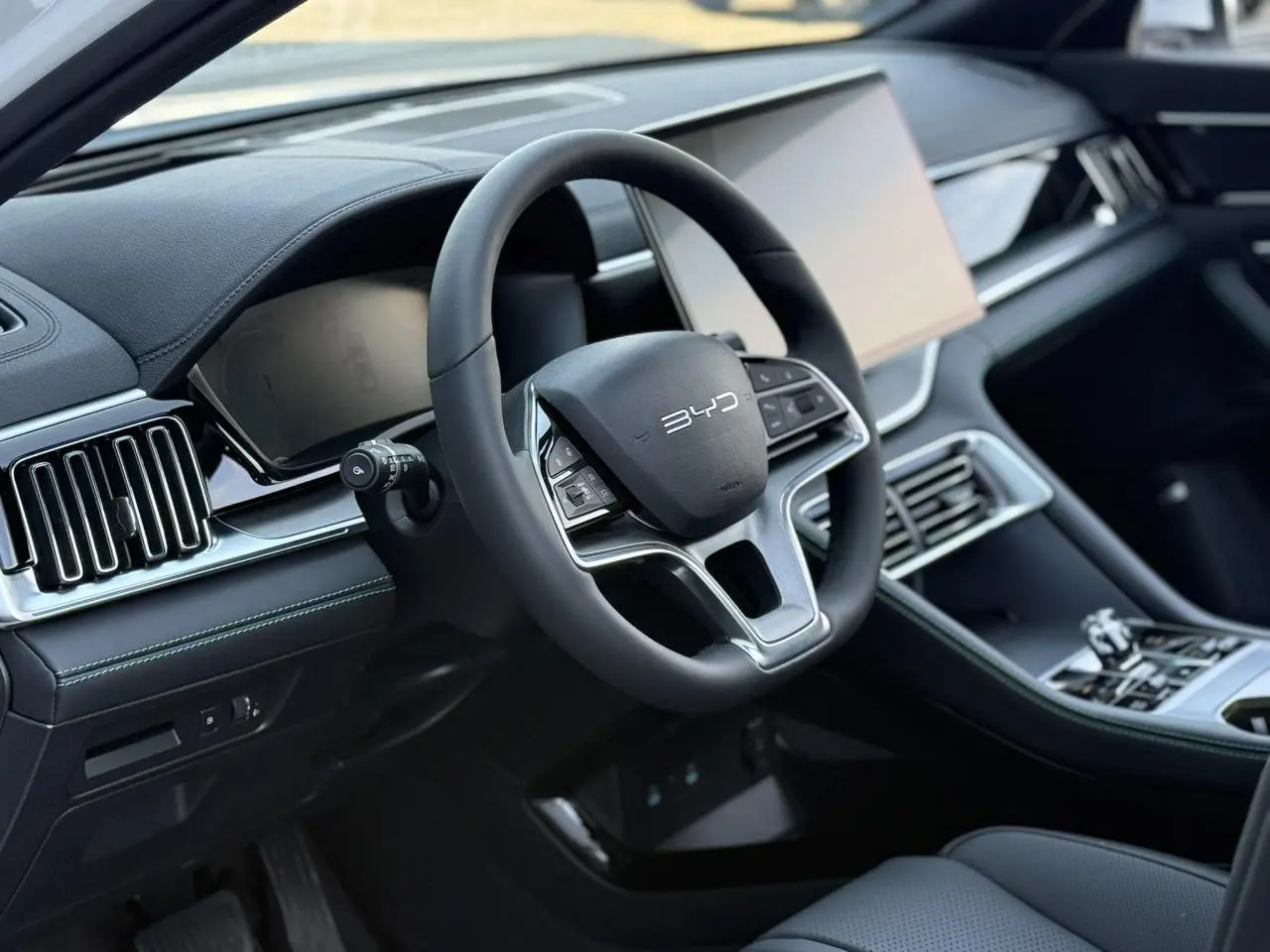 Vue intérieure centrée sur le volant noir multifonction du BYD SEAL U avec tableau de bord et console moderne.
