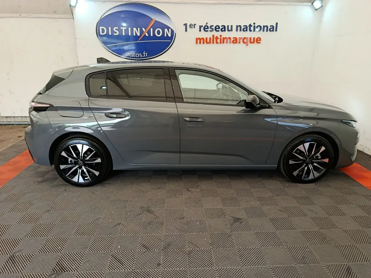 Peugeot 308 BlueHDi 130 gris foncé vue de profil côté gauche, jantes alliage noires et grises distinctives.