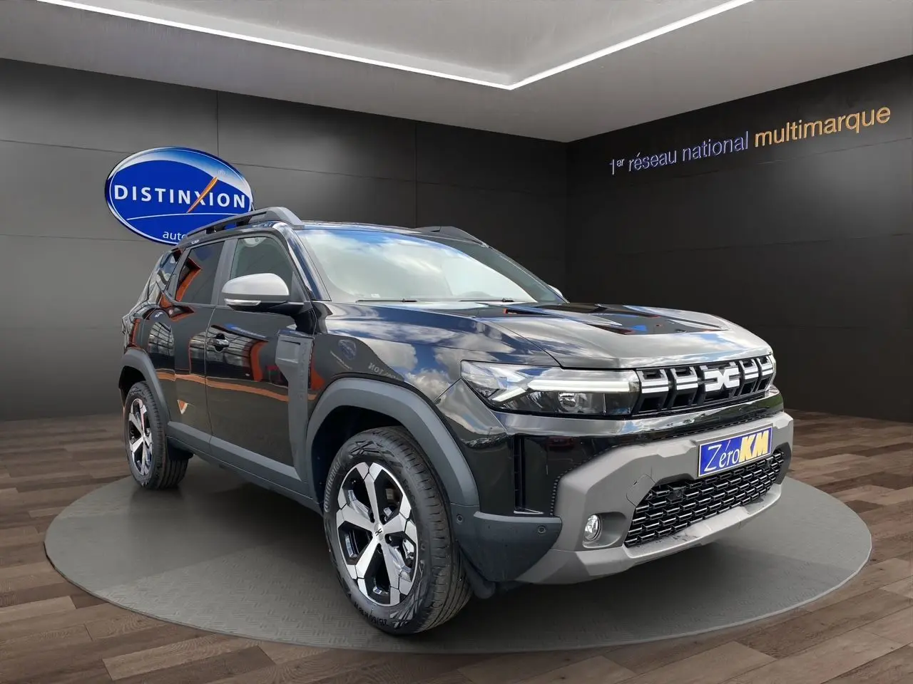 Dacia Duster hybride noir en 3/4 avant droit, avec calandre distinctive et jantes alliage modernes.