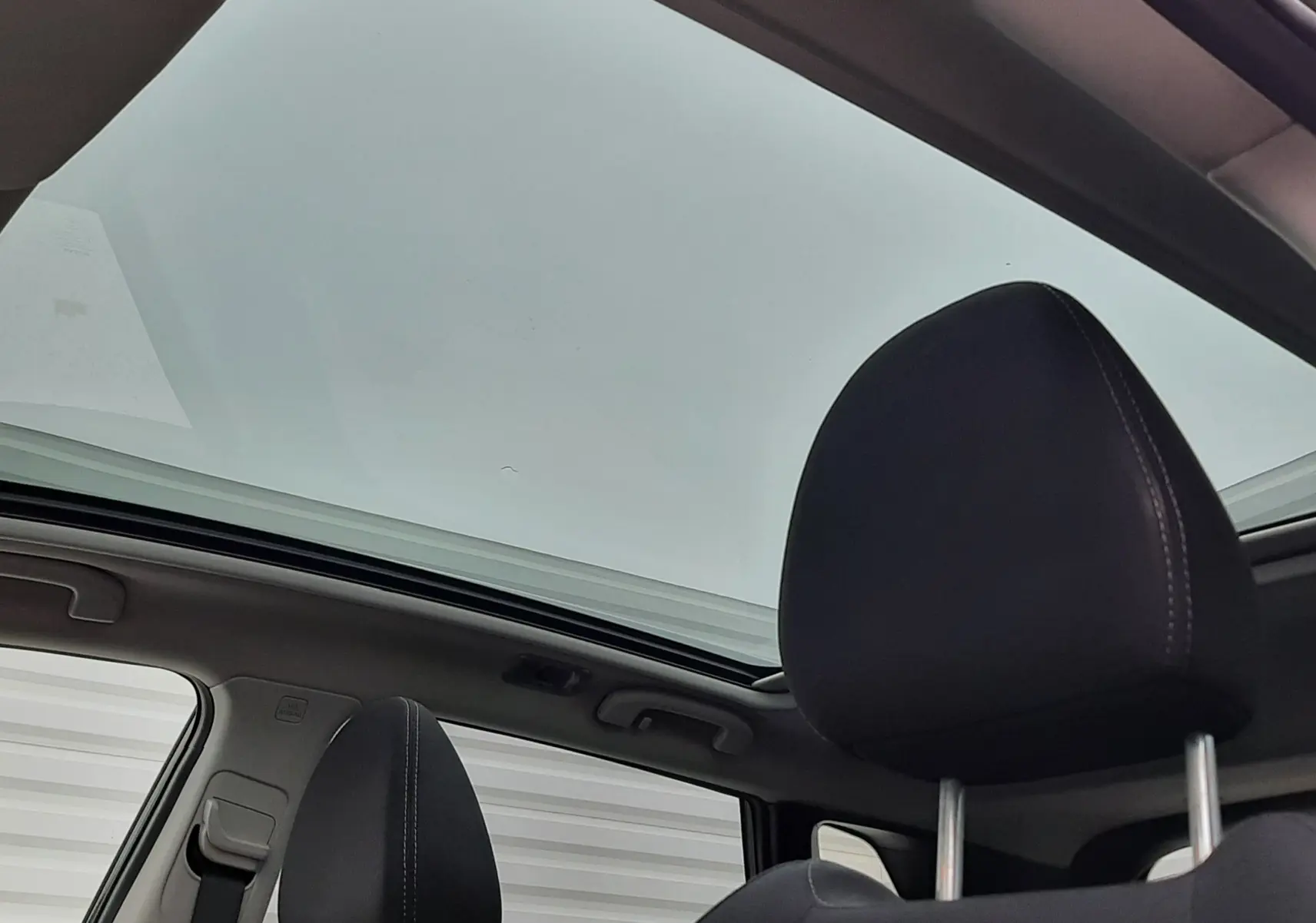 Vue intérieure du toit ouvrant panoramique et des sièges avant noirs du Nissan Qashqai DCI 115 N-Connecta 2020.