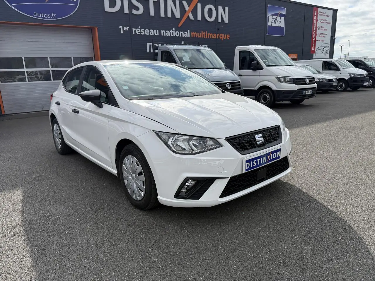 SEAT Ibiza blanc Candy vue 3/4 avant droit, avec phares antibrouillard et enjoliveurs 15 pouces visibles.