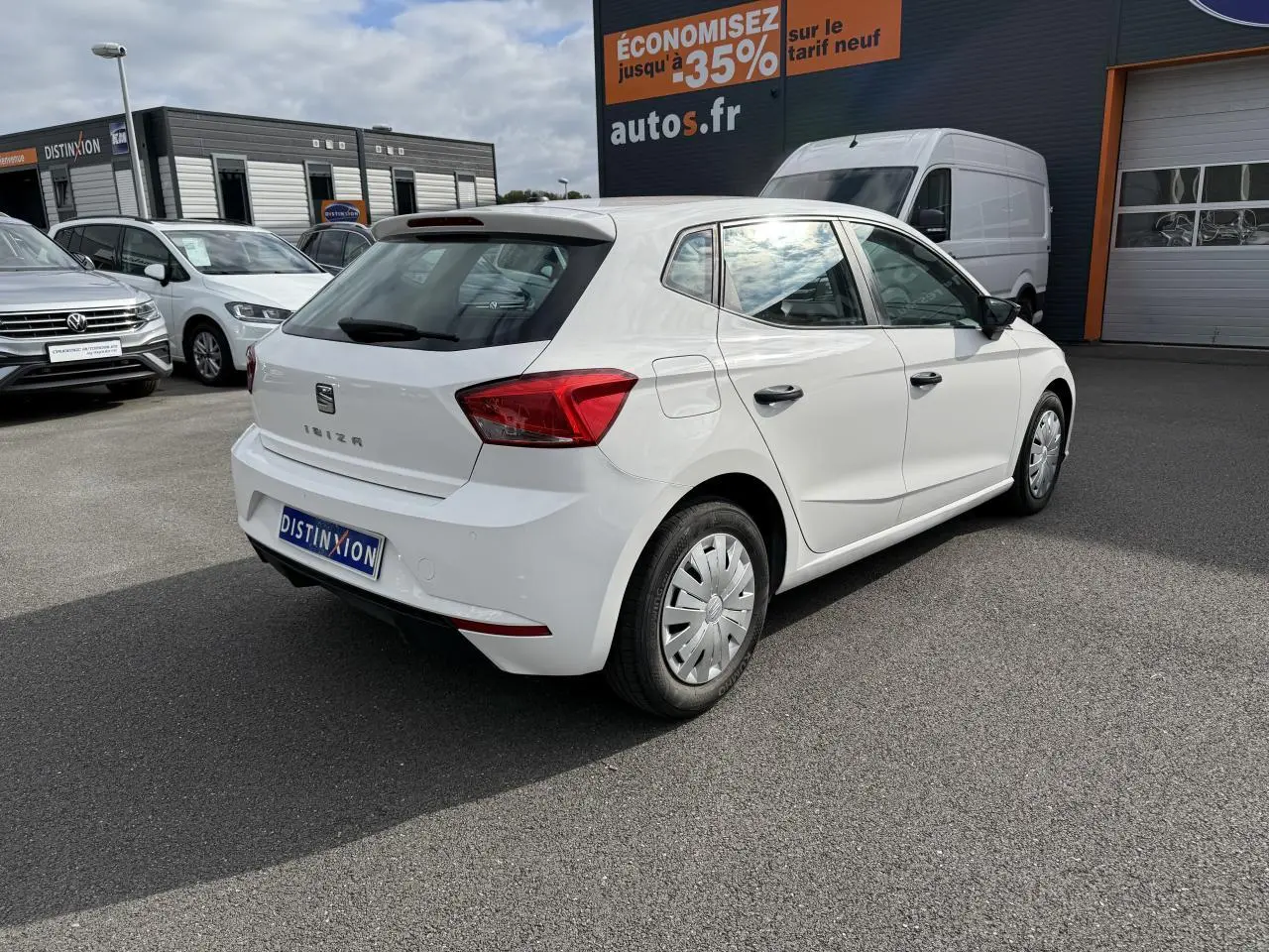SEAT Ibiza blanc candy vue 3/4 arrière droit, avec enjoliveurs de roue et rétroviseurs noirs visibles.