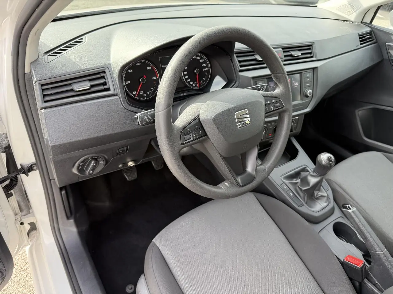 Intérieur côté conducteur de la SEAT Ibiza blanc Candy 2019, volant multifonction et boîte manuelle visibles.