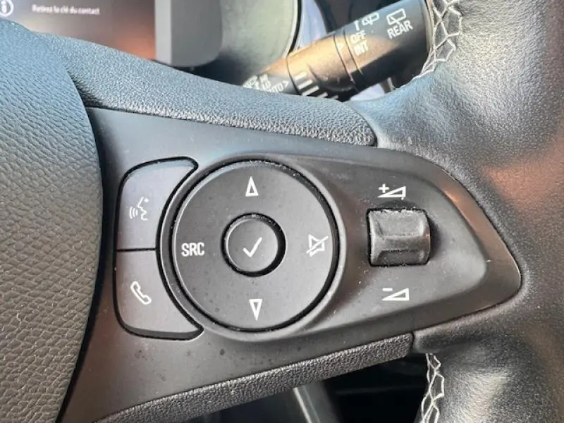 Gros plan sur les commandes audio au volant cuir de l'Opel Corsa 1.2 Turbo 2022, finition Elegance.
