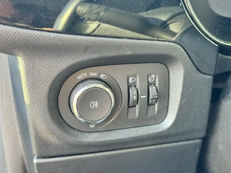 Gros plan sur les commandes d'éclairage intérieures en plastique noir de l'Opel Corsa 1.2 Turbo bleu Voltaïque 2022.
