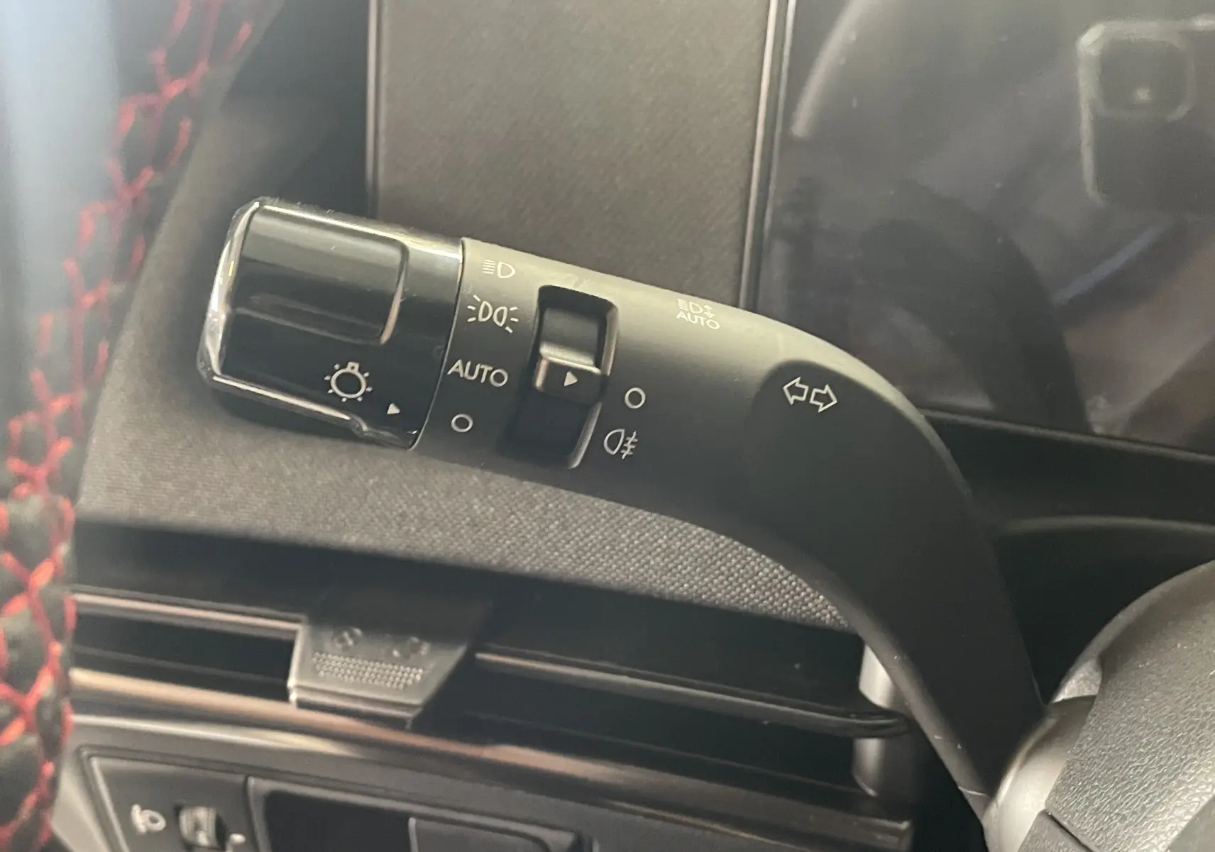 Gros plan sur la commande des feux et clignotants à gauche du volant d’un Hyundai Tucson gris Ecotronic 2025.