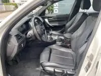 Intérieur noir de la BMW Série 1 114d M Sport 2018, vue côté conducteur montrant sièges et tableau de bord.