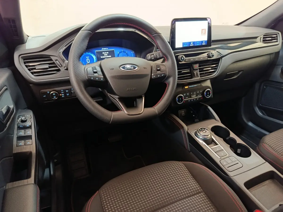 Vue intérieure avant du Ford Kuga 2024 avec tableau de bord numérique et écran tactile central.