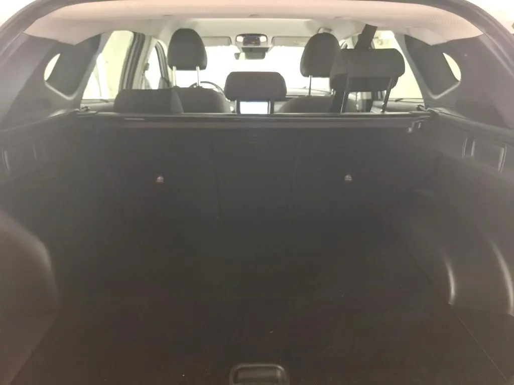 Détail des commandes de lève-vitres et rétroviseurs sur la porte côté conducteur d'un Hyundai Tucson blanc 2021.