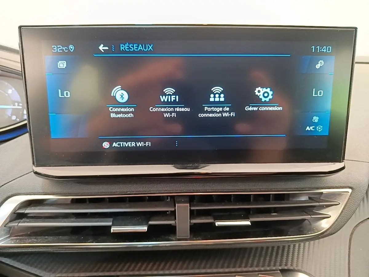 Écran tactile central du tableau de bord du Peugeot 3008 gris foncé, affichant les options de connexion Wi-Fi et Bluetooth.