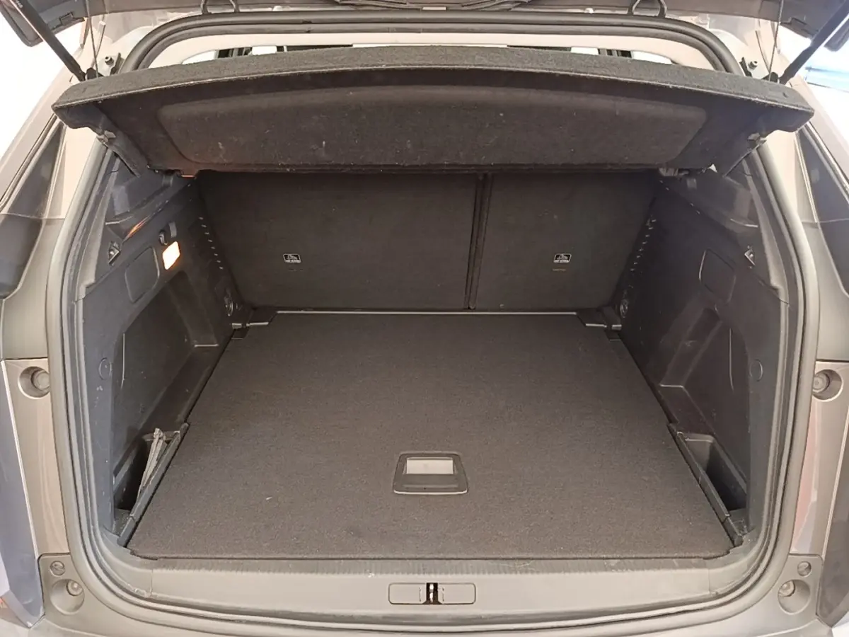 Coffre ouvert d’un Peugeot 3008 gris foncé vu de l’arrière, montrant un espace de chargement propre et spacieux.