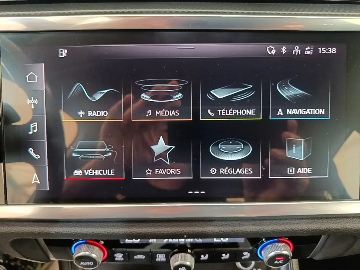 Écran tactile central de l’Audi Q3 45 TFSI e 2023 affichant le menu multimédia et navigation, intérieur noir.