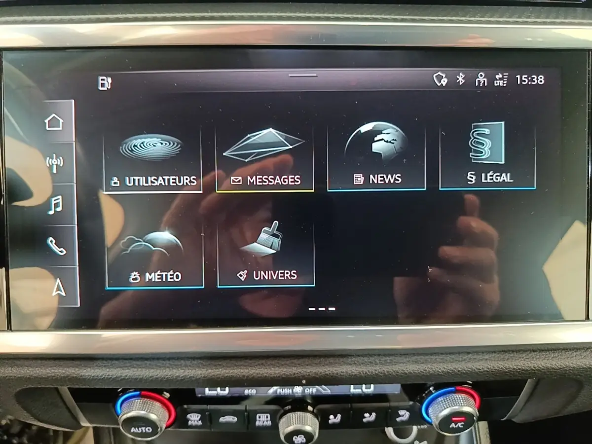 Écran tactile central de l’Audi Q3 45 TFSI e 2023 affichant les menus utilisateurs, messages, news, météo et univers.