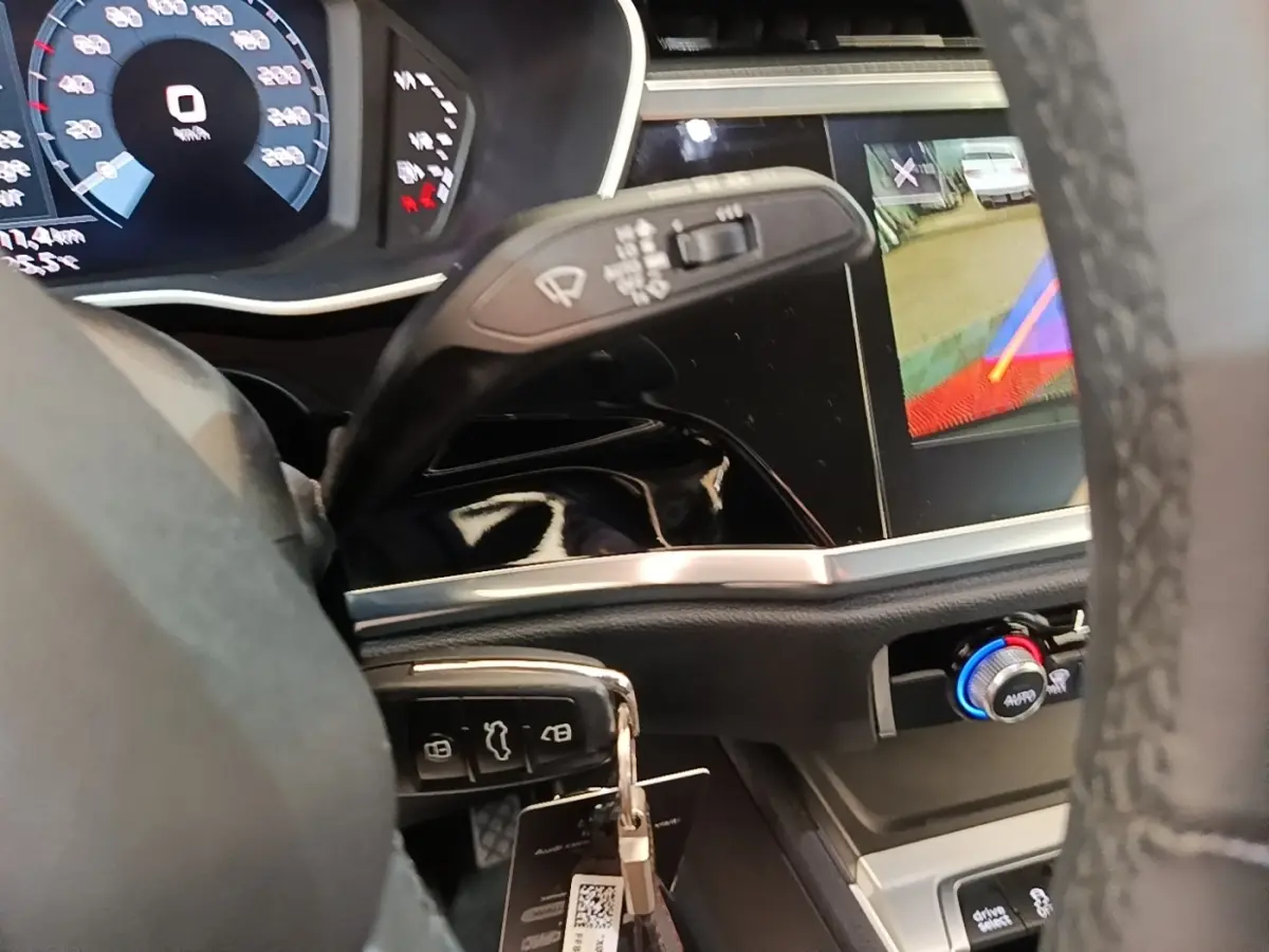 Vue intérieure du tableau de bord de l'Audi Q3 45 TFSI E 2023 avec affichage numérique et commande de climatisation.