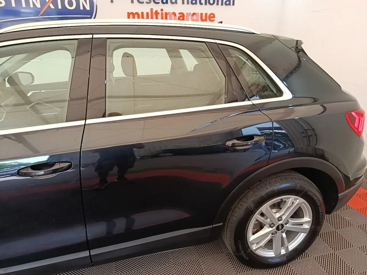 Vue latérale côté droit d’un Audi Q3 hybride rechargeable 2023 noir avec jantes alliage et vitres teintées.