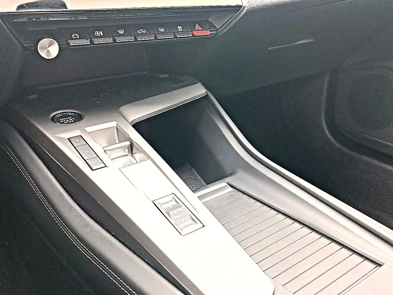Vue intérieure de la console centrale de la Peugeot 408 Hybrid 145 allure 2024, avec commandes de boîte auto et bouton Drive Mode.