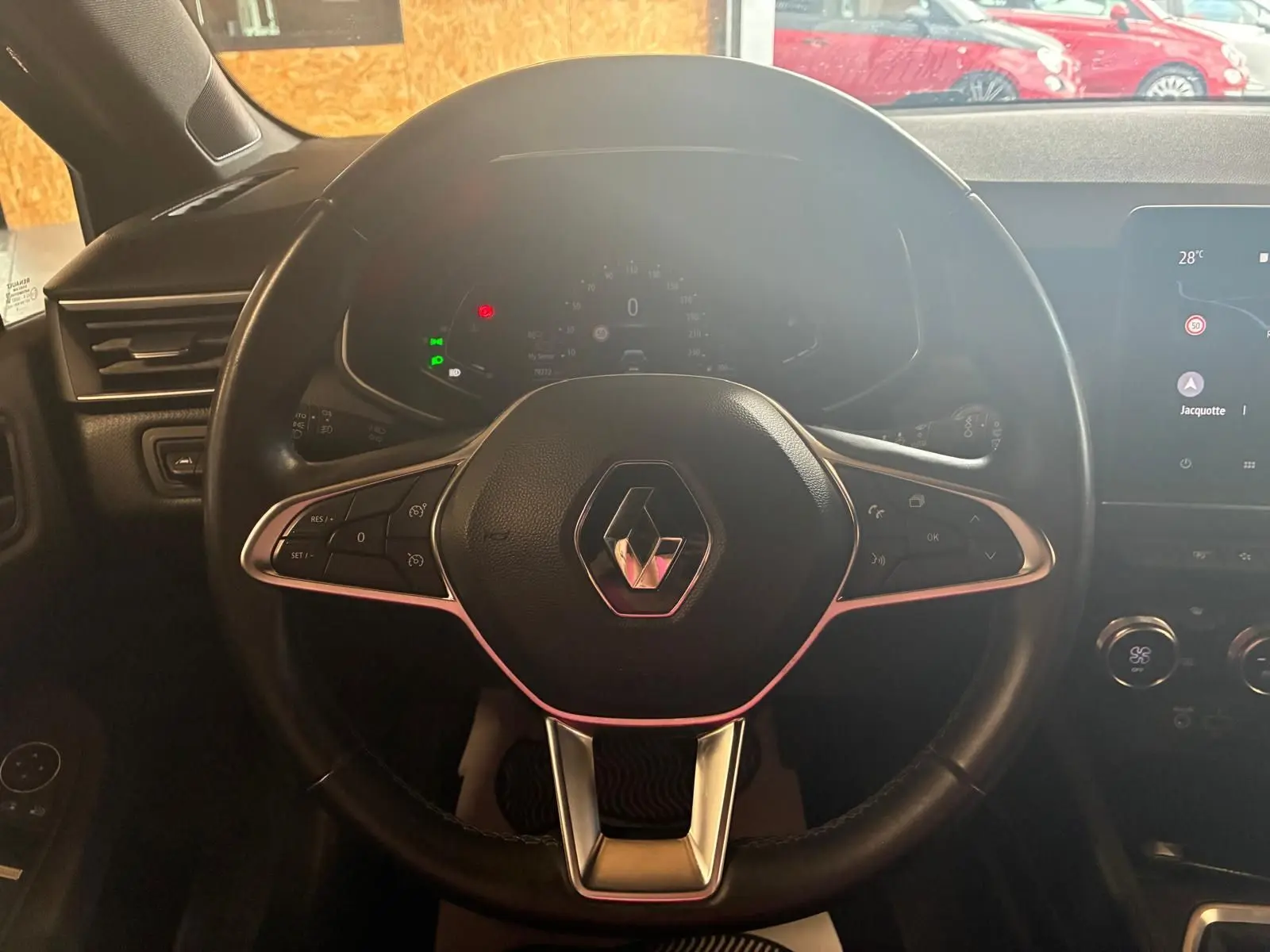 Volant noir de Renault Clio 2020 avec commandes intégrées, tableau de bord numérique et écran tactile visible à droite.