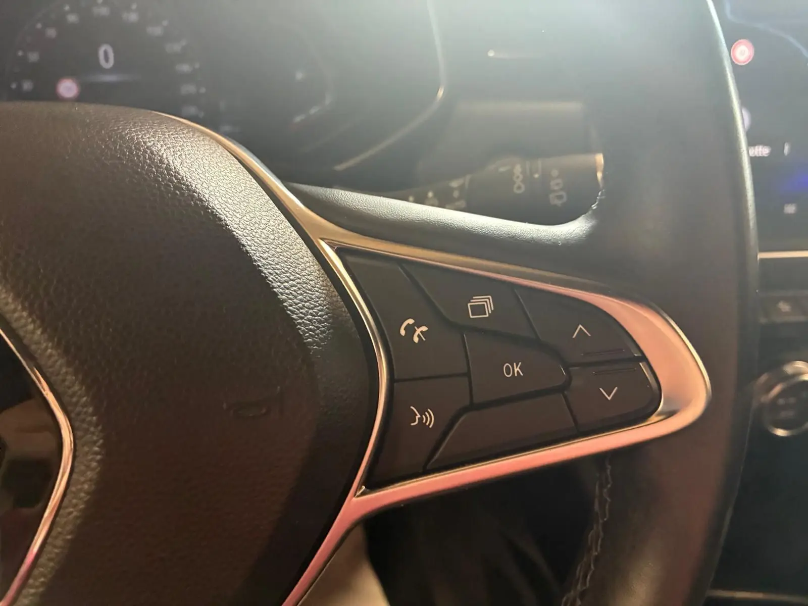 Gros plan sur les commandes multifonctions à droite du volant d'une Renault Clio gris 2020, finition Intens.