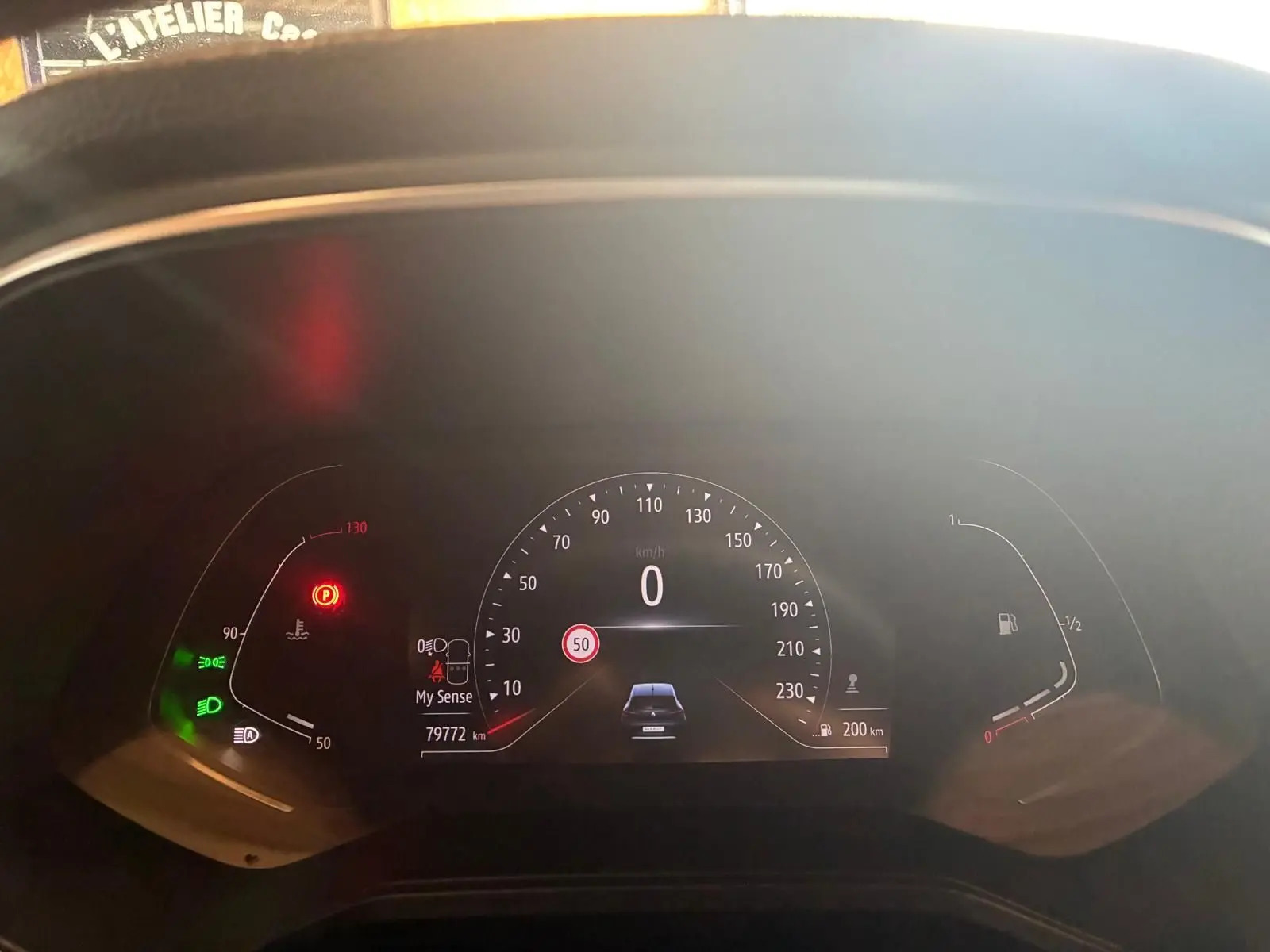 Tableau de bord numérique de Renault Clio 2020 gris, affichant la vitesse à 0 km/h et témoins allumés.