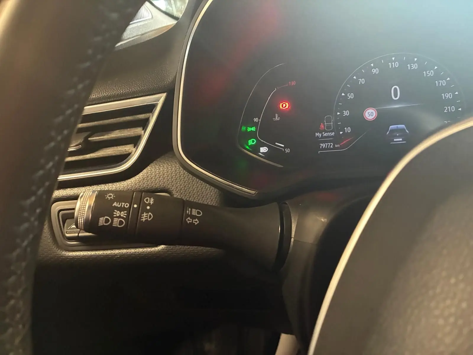 Vue rapprochée du tableau de bord et du commodo gauche de la Renault Clio gris 2020, affichant le compteur digital et témoins lumineux.