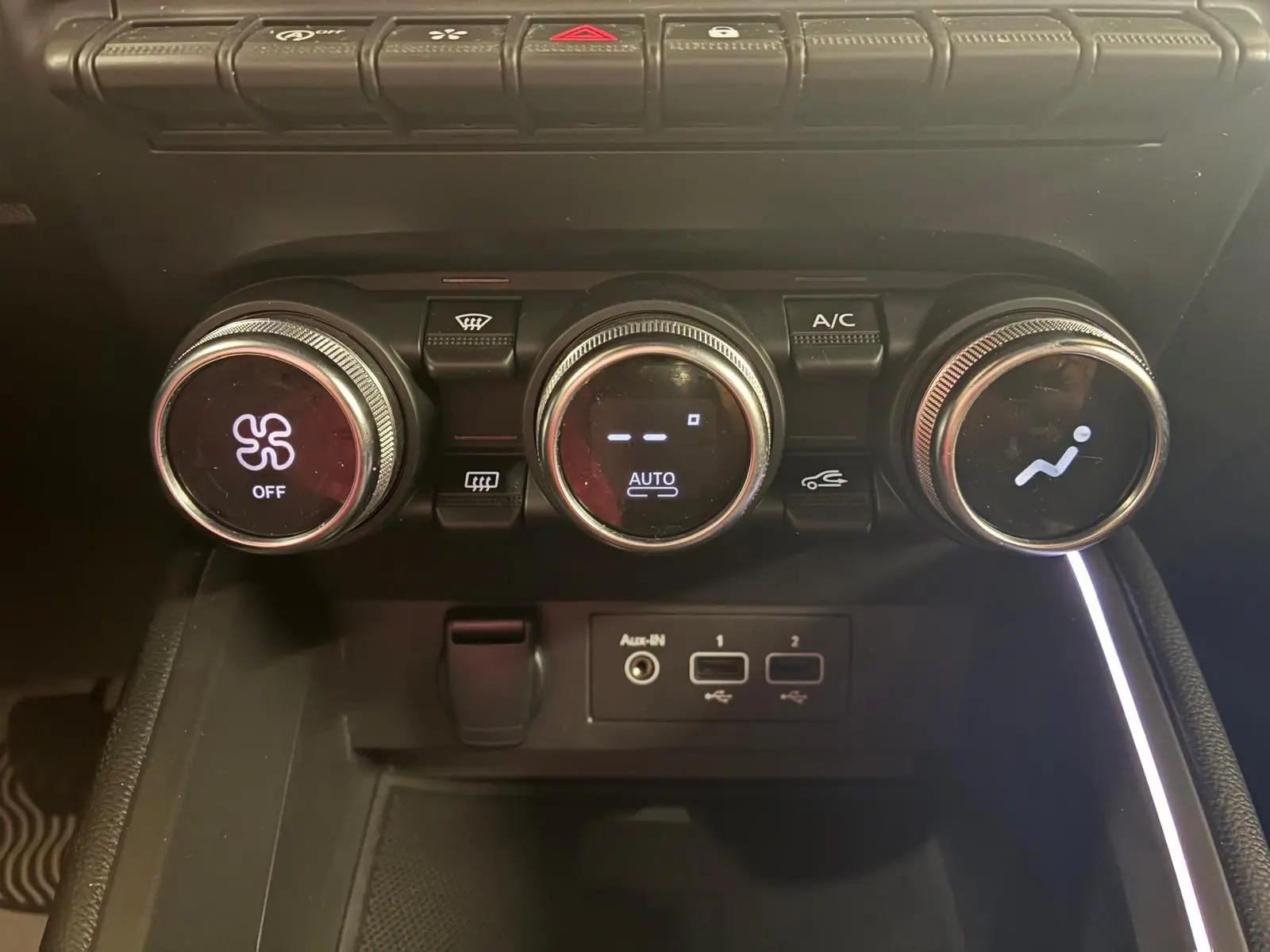 Gros plan sur les commandes de climatisation et les ports USB d'une Renault Clio 1.0 TCE 100 Intens gris, année 2020.