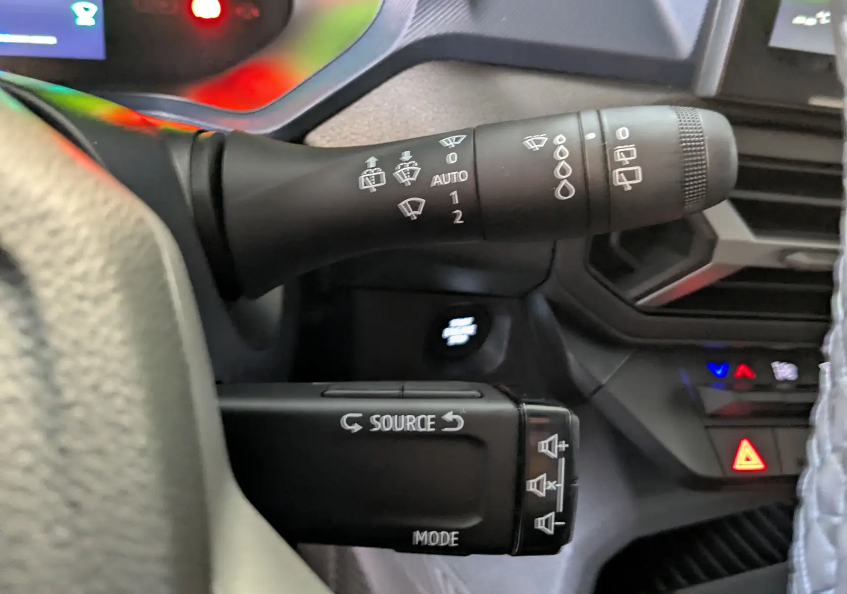 Gros plan sur les commandes au volant du Dacia Duster Hybrid 140 Journey 2025, intérieur noir avec détails fonctionnels.