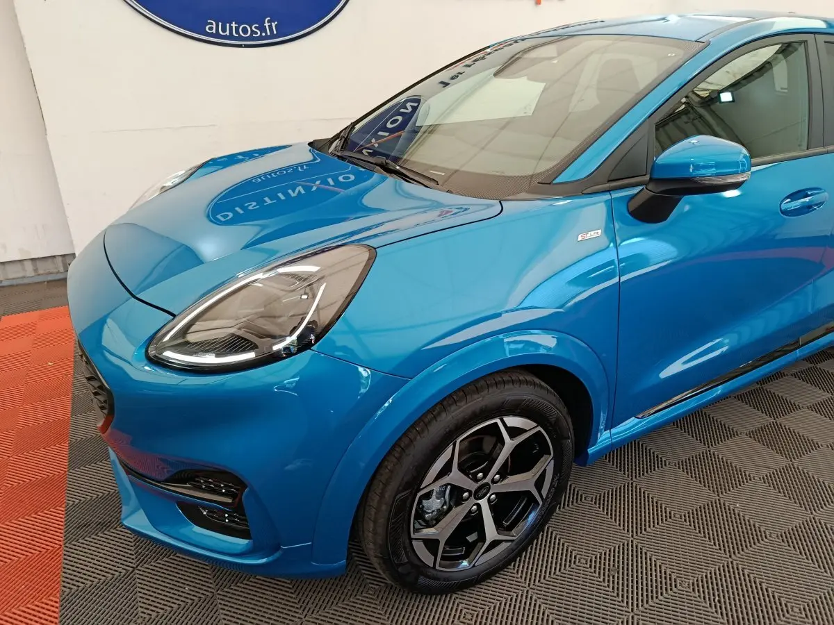 Vue 3/4 avant droit d'une Ford Puma bleue avec phares LED et jantes alliage distinctives en concession.
