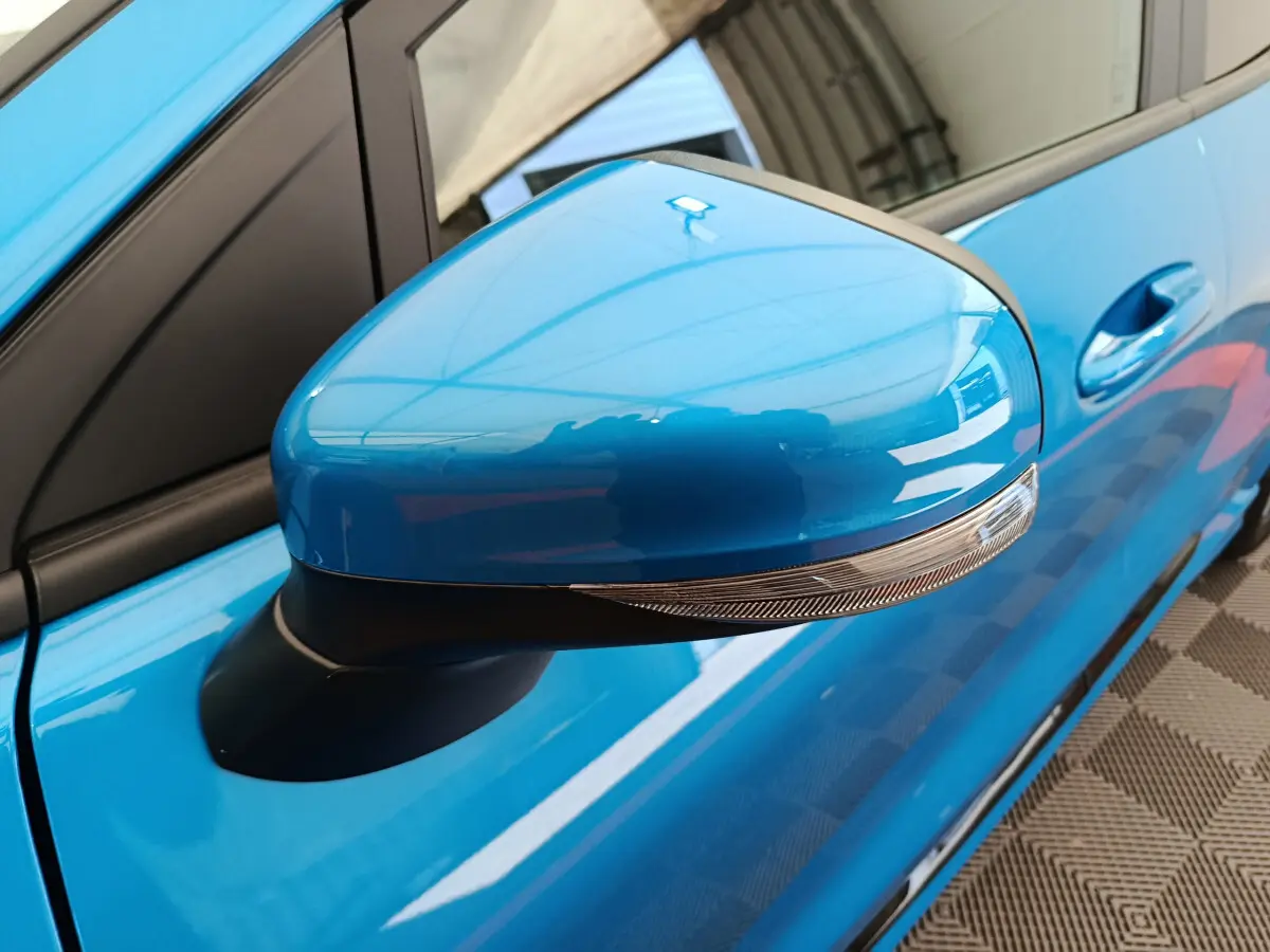 Rétroviseur droit bleu vif du Ford Puma 2025 ST-LINE avec clignotant intégré, vue rapprochée côté conducteur.