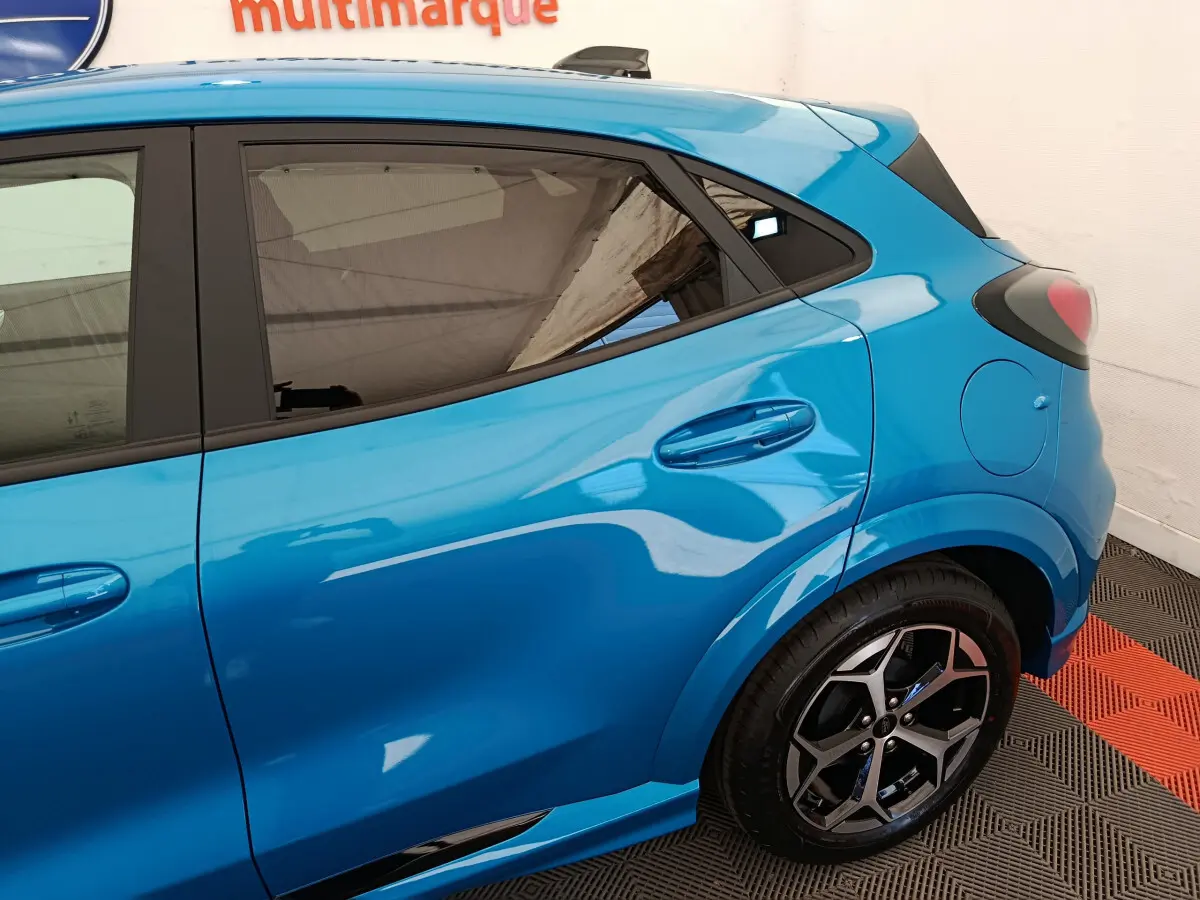 Vue côté droit arrière du Ford Puma bleu 2025 avec jantes alliage et vitres teintées.