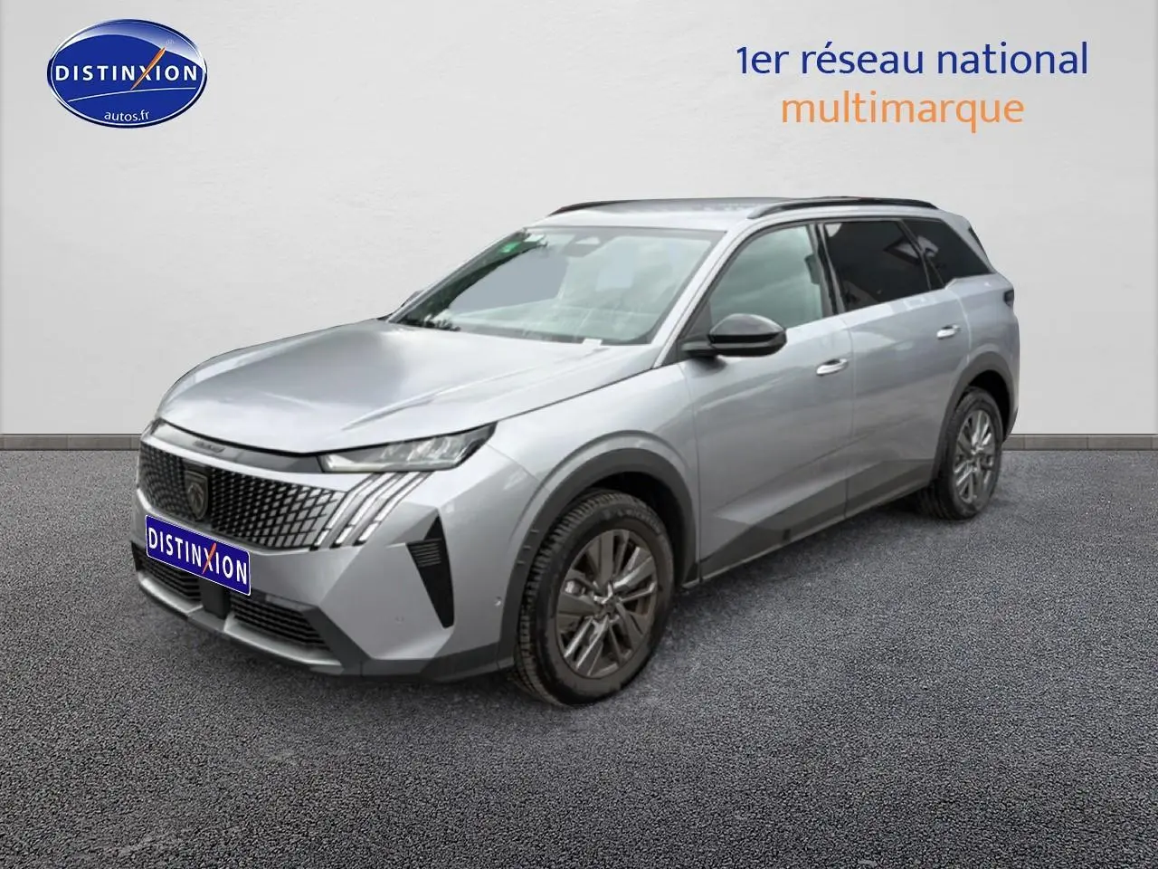 Peugeot 5008 Hybrid 145 gris artense en 3/4 avant droit avec calandre distinctive et jantes alu.