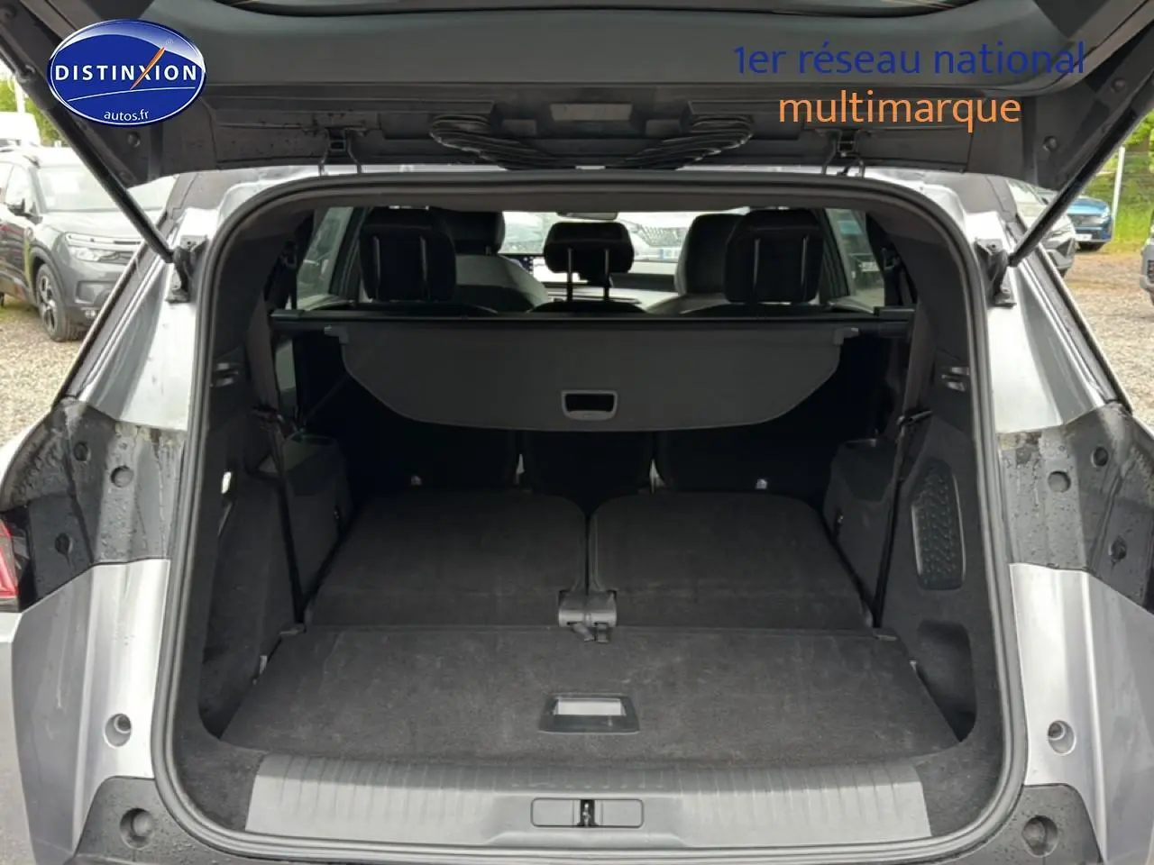 Coffre ouvert vu de l’arrière d’un Peugeot 5008 gris artense avec banquette arrière rabattue à plat.
