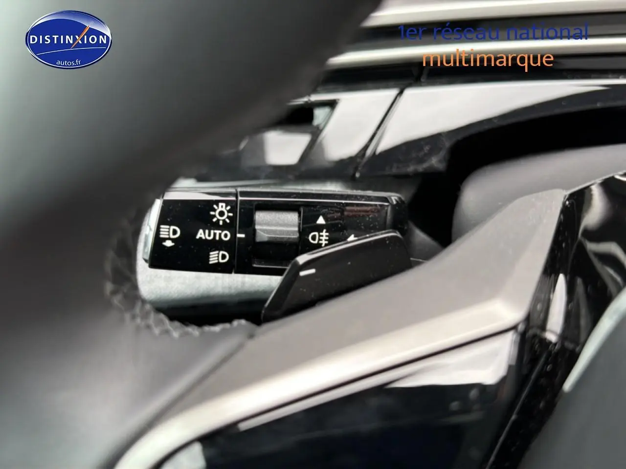 Gros plan sur la commande des phares automatique à gauche du volant du Peugeot 5008 gris Artense 2025.