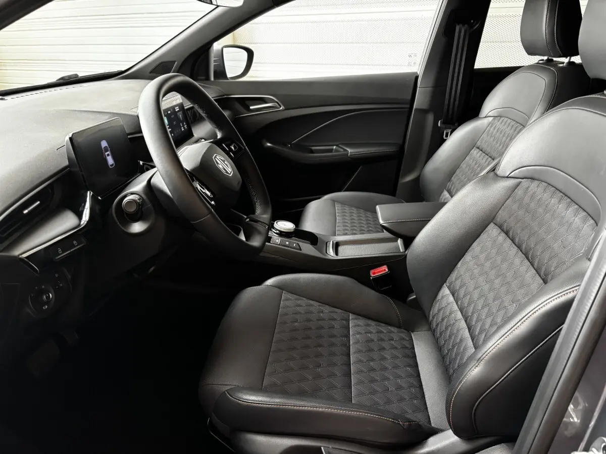 Vue intérieure côté conducteur de la MG3 1.5L Hybrid+ Luxury 2025 avec sièges en cuir noir et volant multifonctions chauffant en suède.