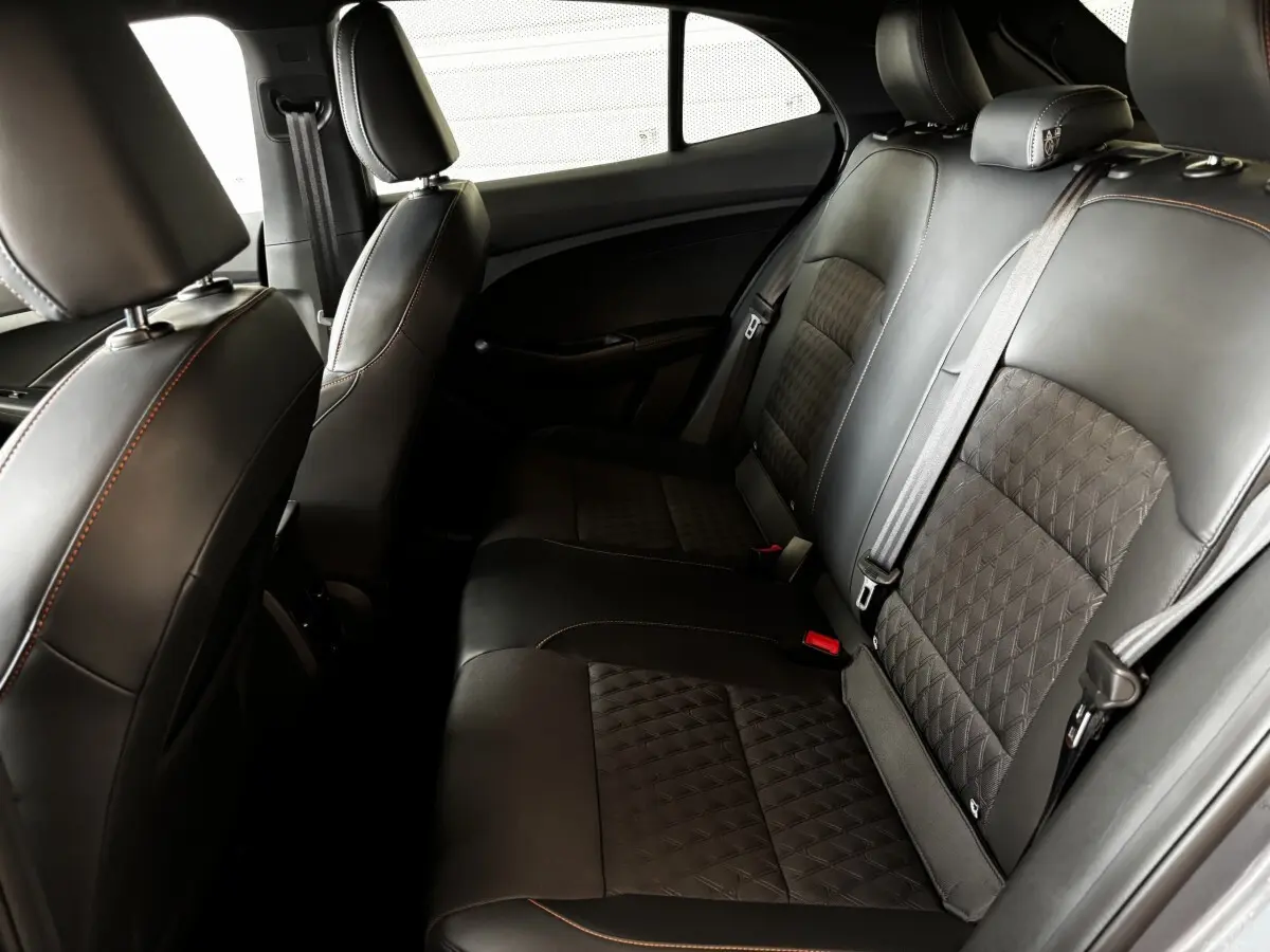 Vue intérieure côté droit des sièges arrière en cuir noir avec surpiqûres orange du MG3 1.5L Hybrid+ Luxury 2025.