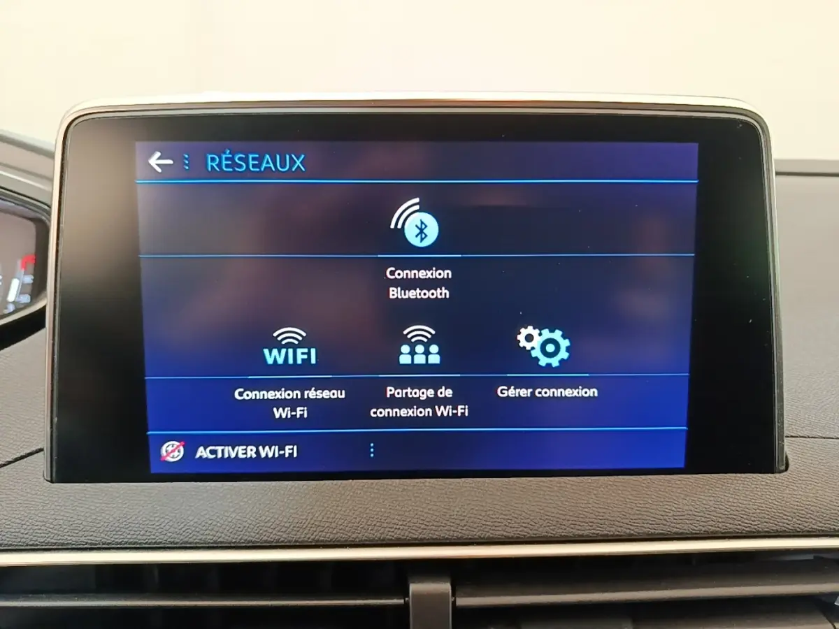 Écran tactile central du tableau de bord du Peugeot 3008 noir, affichant les options de connexion réseau Wi-Fi et Bluetooth.