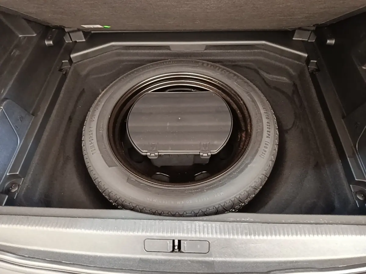 Vue plongeante sur la roue de secours noire dans le coffre d’un Peugeot 3008 noir, version 2018.