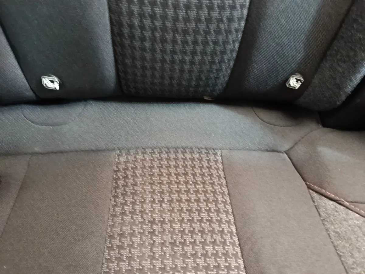 Gros plan sur la banquette arrière noire du Peugeot 3008, tissu à motif et fixations Isofix visibles.
