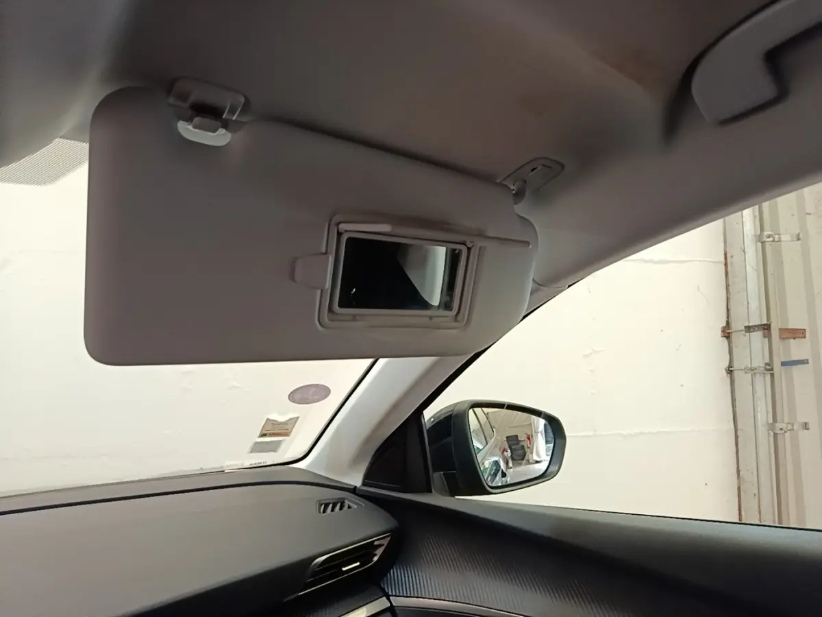 Intérieur du Peugeot 3008 noir, vue côté gauche sur pare-soleil avec miroir et rétroviseur extérieur.